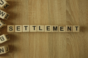 Settlement word from wooden blocks on desk