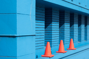 Orange traffic cones and a blue brick wall